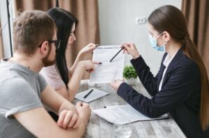 A person reviews COBRA paperwork, premium details, and enrollment deadlines at a kitchen table.